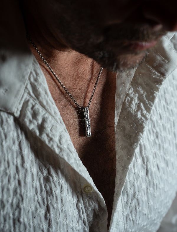 Collier avec pendentif carré porté par un homme